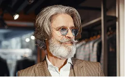 Hombre maduro con barba, gafas y traje a rayas