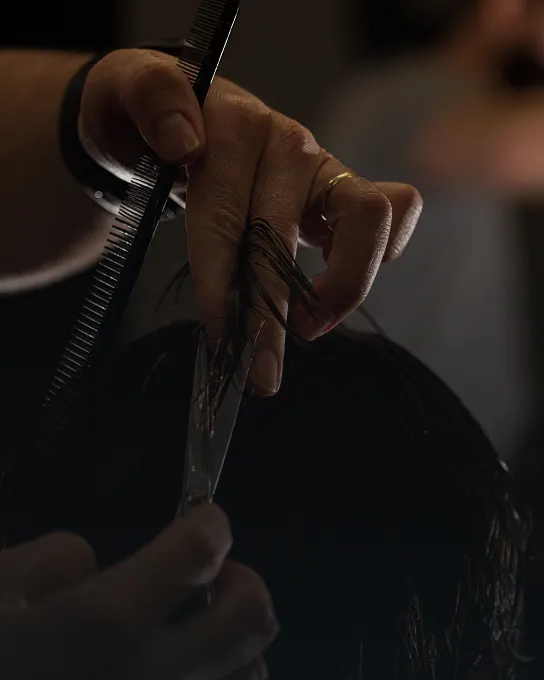 Corte de cabello masculino con visagismo, detalle de tijera y peine